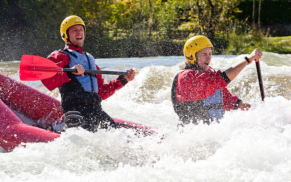 Actionreicher Moment im Schlauchkanadier beim Wildwasserabschnitt der Isar