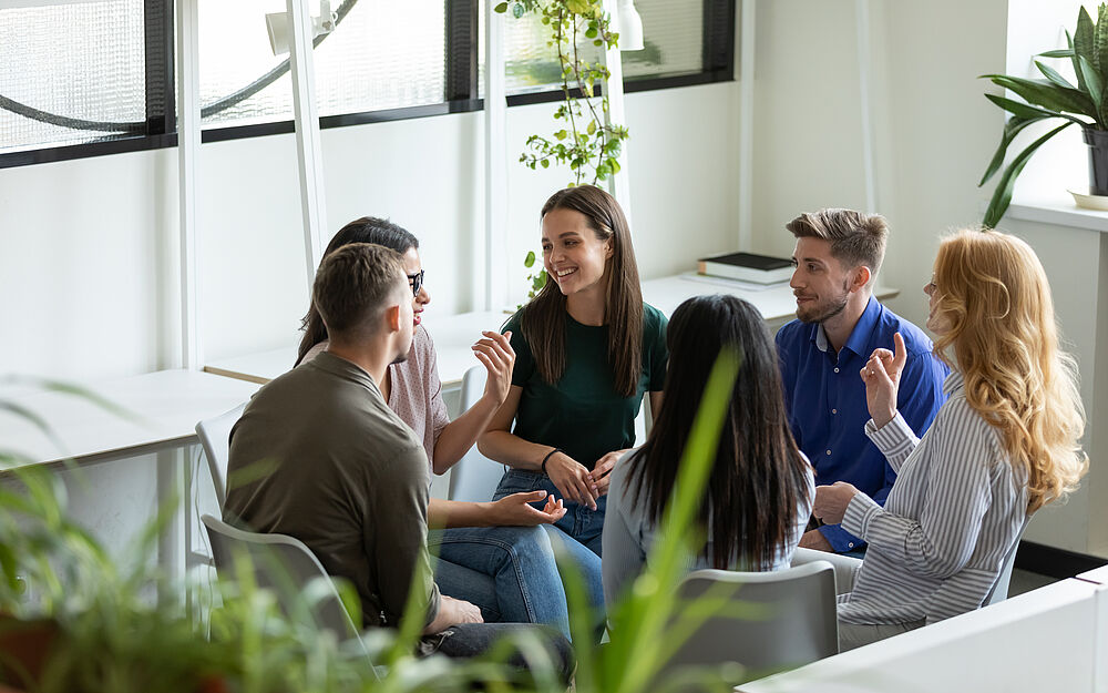 Teilnehmende sitzen beim Montevia-Workshop im Kreis und tauschen sich miteinander aus